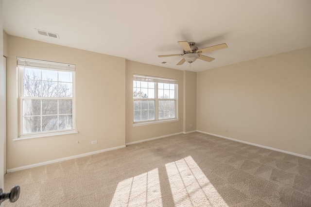 carpeted spare room featuring ceiling fan