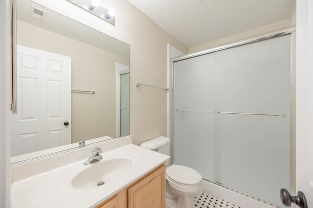 bathroom featuring tile patterned flooring, toilet, vanity, and walk in shower