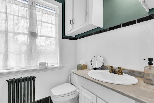 bathroom featuring vanity, toilet, and radiator