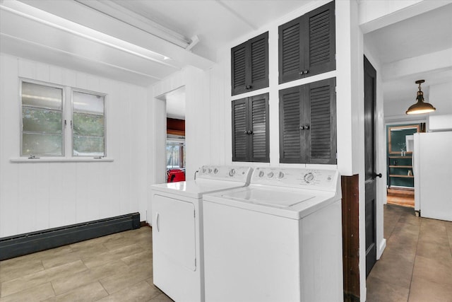 laundry area with baseboard heating, washing machine and dryer, and wood walls