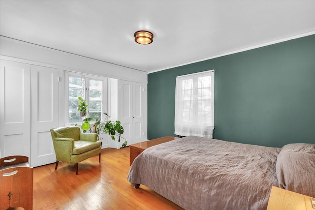 bedroom with hardwood / wood-style flooring and ornamental molding