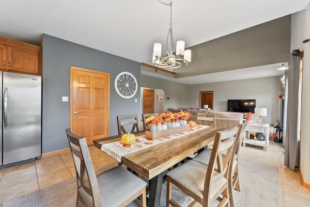 dining space with light tile patterned flooring and an inviting chandelier