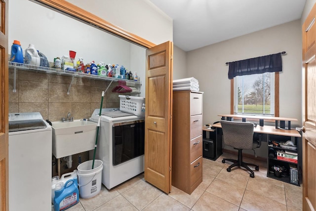 clothes washing area with light tile patterned floors, washer / clothes dryer, and sink