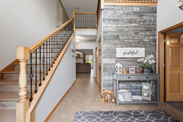 stairs featuring tile patterned floors and a towering ceiling