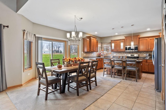 dining space featuring an inviting chandelier and light tile patterned flooring