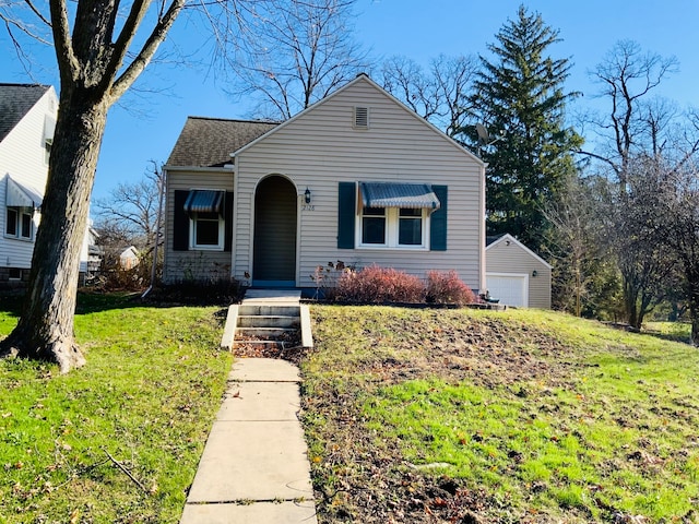 bungalow featuring an outbuilding, a front lawn, and a garage