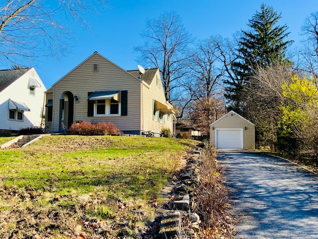 view of front facade featuring an outbuilding, a garage, and a front lawn