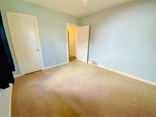 unfurnished bedroom with ceiling fan and light carpet