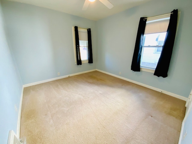 spare room featuring ceiling fan and light colored carpet