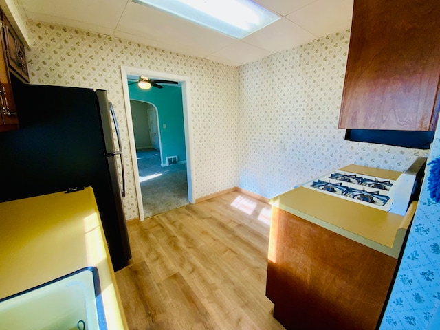 kitchen featuring light hardwood / wood-style flooring, ceiling fan, and stainless steel refrigerator