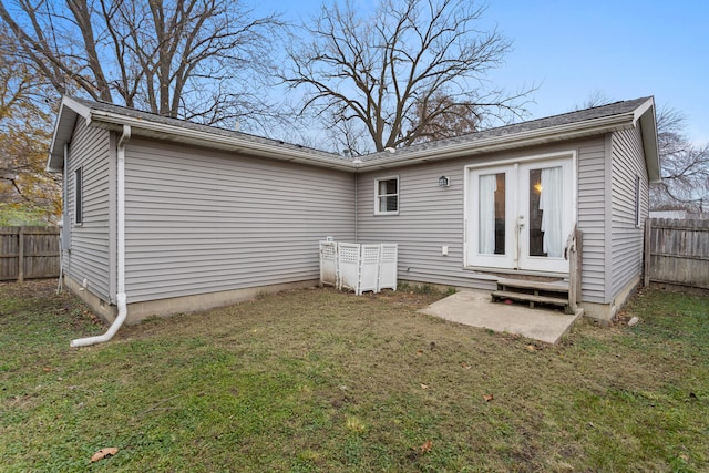 rear view of house with french doors and a lawn