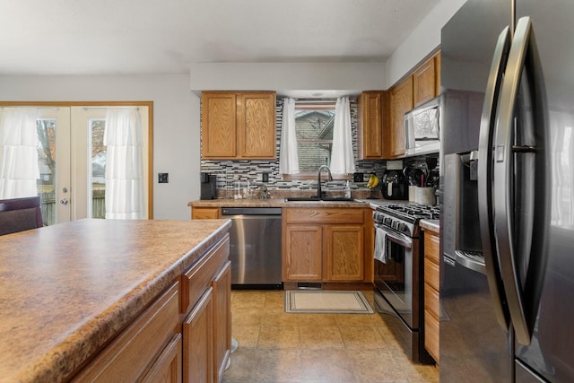 kitchen with decorative backsplash, sink, appliances with stainless steel finishes, and french doors