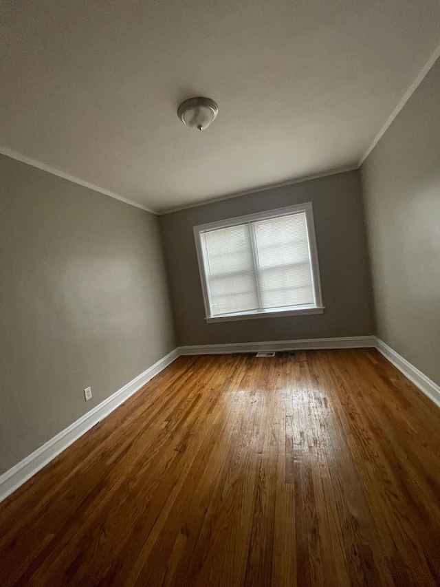 unfurnished room with hardwood / wood-style floors and ornamental molding