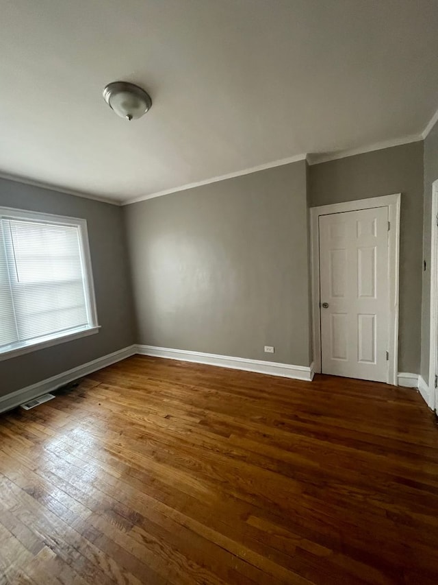 spare room with crown molding and dark hardwood / wood-style floors