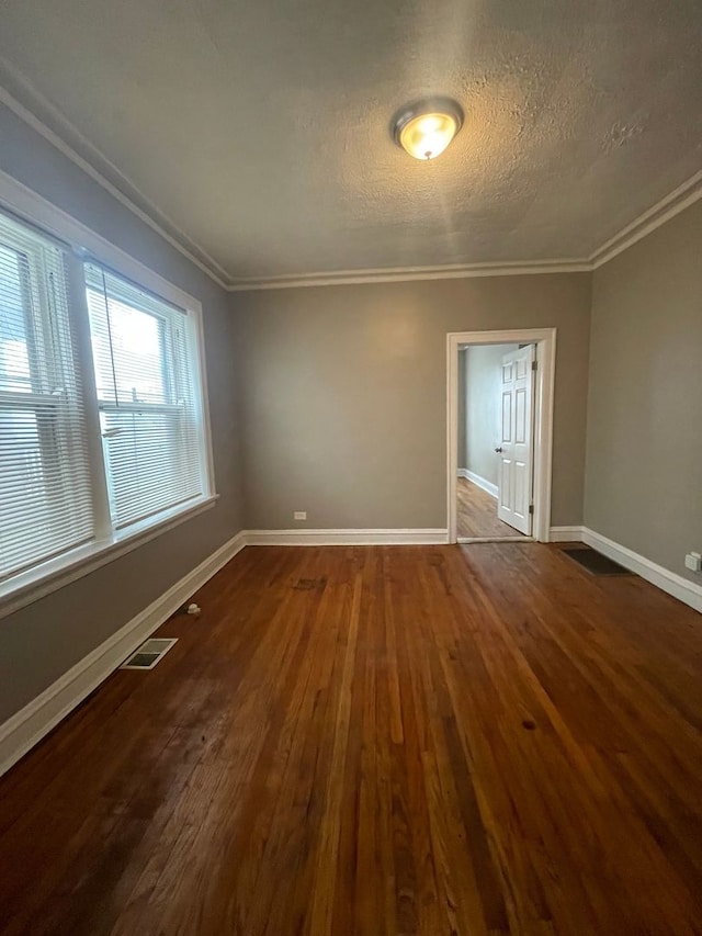 spare room featuring ornamental molding, a textured ceiling, and hardwood / wood-style flooring