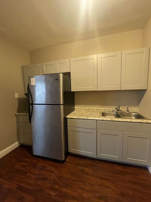 kitchen featuring stainless steel fridge, dark wood-type flooring, and sink