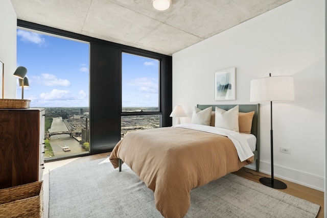 bedroom featuring wood-type flooring and floor to ceiling windows