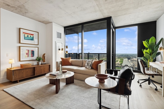 living room with light wood-type flooring and a wall of windows