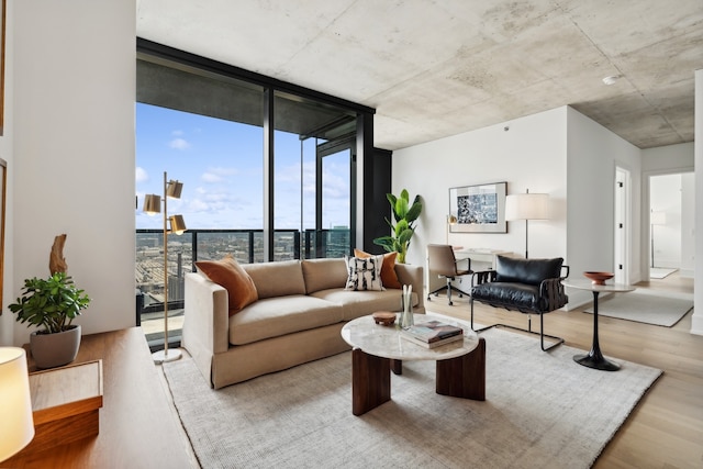 living room with a wall of windows and light hardwood / wood-style flooring