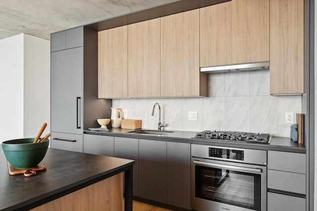 kitchen featuring sink, light hardwood / wood-style flooring, backsplash, exhaust hood, and appliances with stainless steel finishes