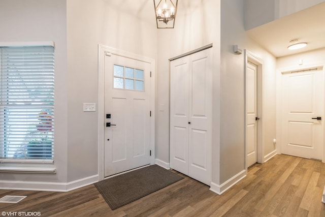 entryway featuring wood-type flooring and an inviting chandelier