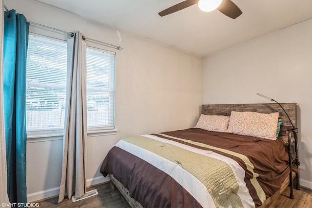 bedroom with dark hardwood / wood-style floors and ceiling fan