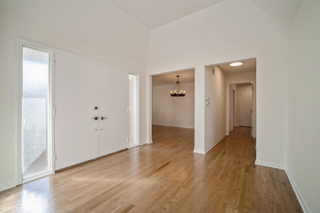 foyer featuring an inviting chandelier, plenty of natural light, and light hardwood / wood-style floors