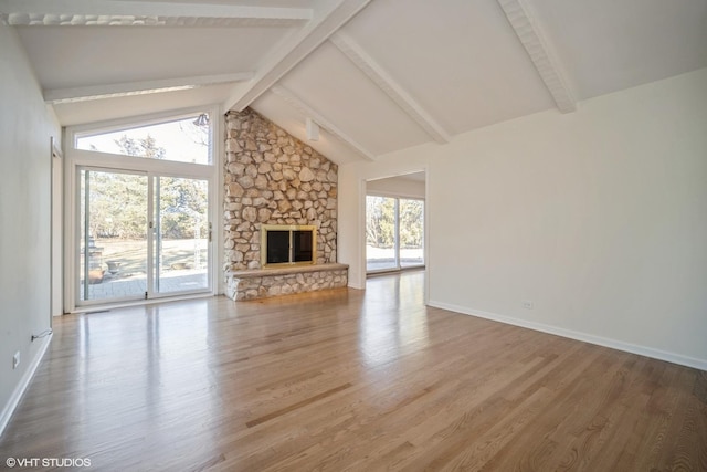 unfurnished living room featuring beam ceiling, hardwood / wood-style flooring, a fireplace, and high vaulted ceiling