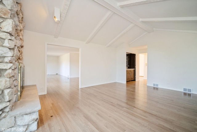 unfurnished room featuring vaulted ceiling with beams, wood-type flooring, and a fireplace