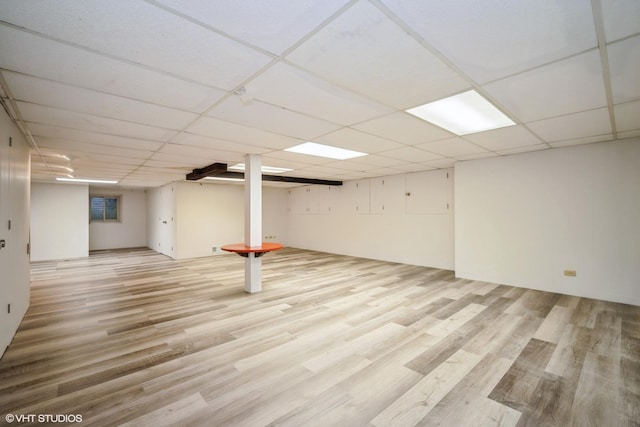 basement featuring light hardwood / wood-style flooring and a paneled ceiling