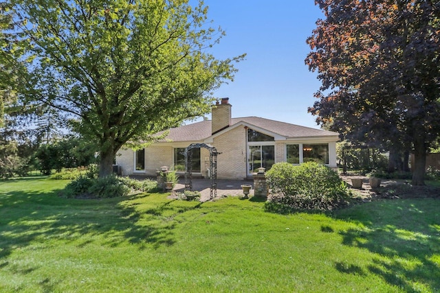 back of house featuring a patio area and a lawn