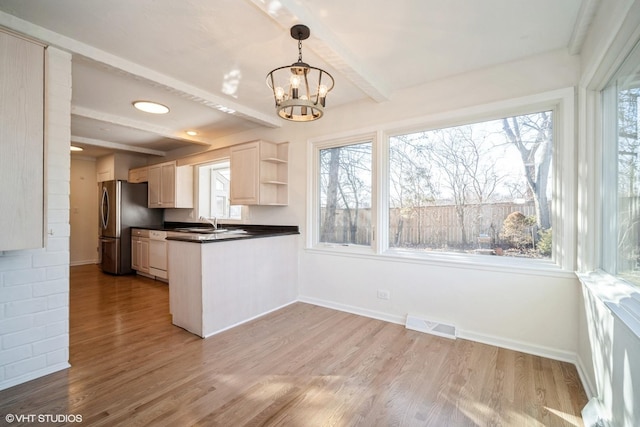 kitchen featuring decorative light fixtures, stainless steel fridge, white dishwasher, beamed ceiling, and light hardwood / wood-style floors