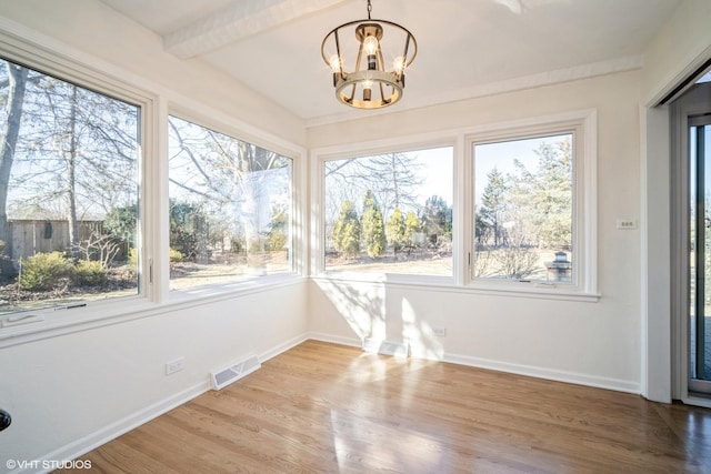 unfurnished sunroom with beamed ceiling and a chandelier