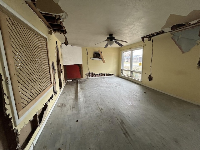 unfurnished living room with ceiling fan and hardwood / wood-style floors