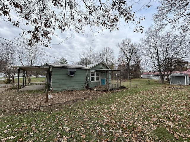 back of house featuring an outbuilding, a yard, and a wall unit AC