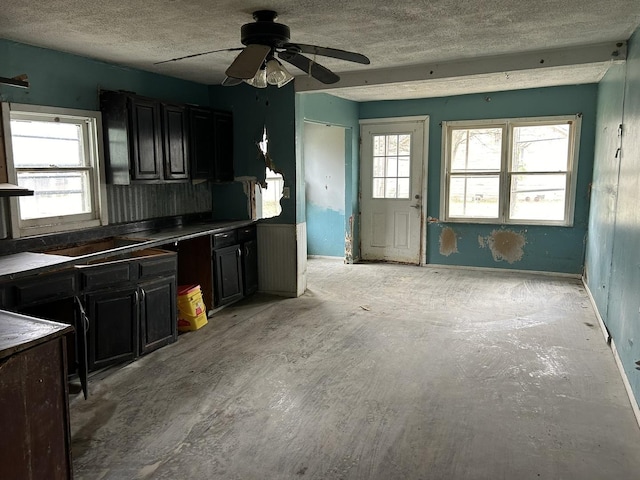 kitchen with a wealth of natural light, ceiling fan, and a textured ceiling