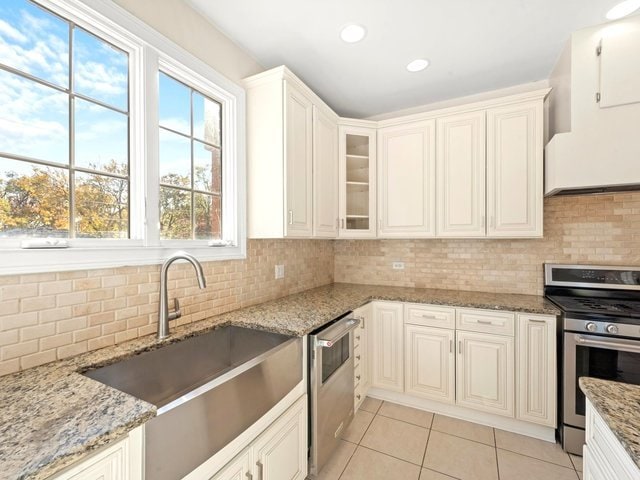 kitchen with light stone countertops, sink, appliances with stainless steel finishes, and tasteful backsplash