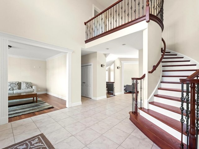 entrance foyer with light hardwood / wood-style flooring, a high ceiling, and ornamental molding