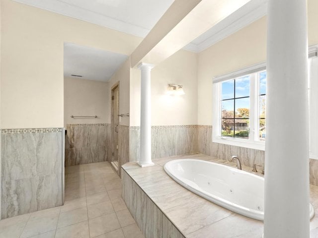 bathroom with tile patterned floors, tiled tub, and ornamental molding