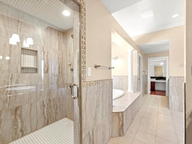 bathroom with tile patterned floors, independent shower and bath, and tile walls