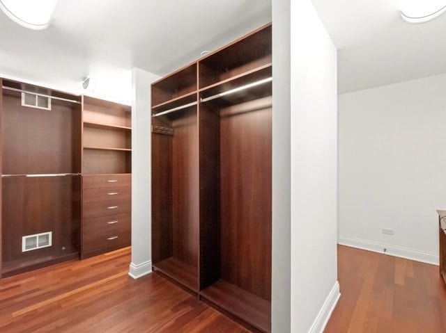 spacious closet with dark hardwood / wood-style flooring