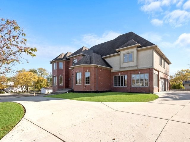 view of side of home featuring a garage and a yard