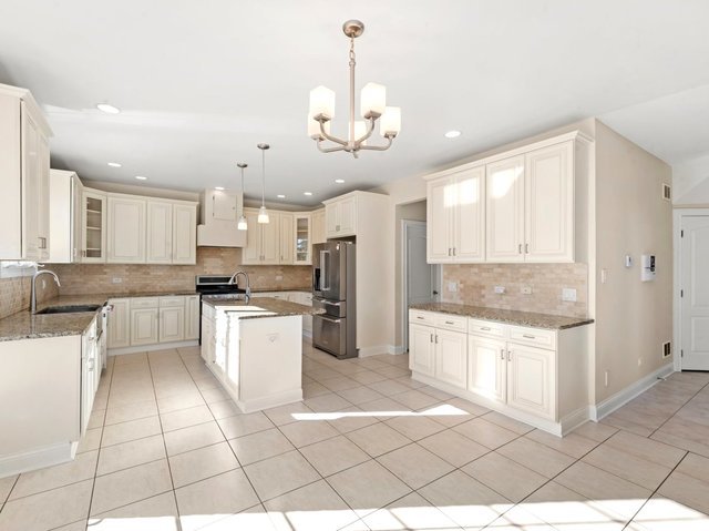 kitchen with tasteful backsplash, a kitchen island with sink, sink, and appliances with stainless steel finishes