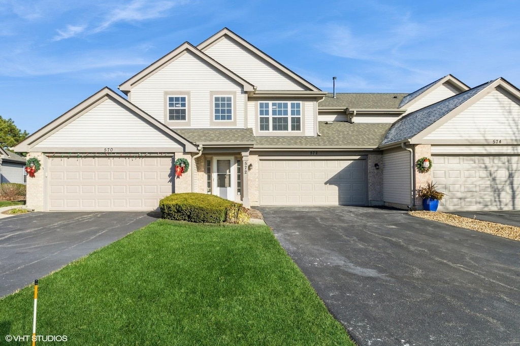 view of front of home with a garage and a front lawn