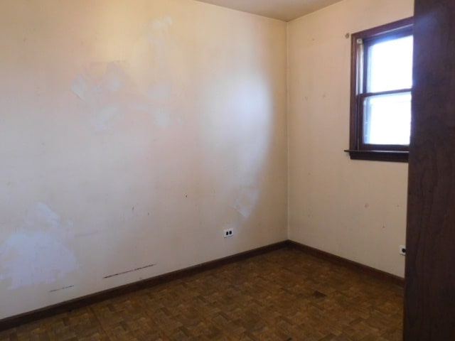 empty room with dark parquet flooring