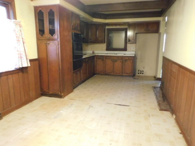 kitchen with double oven and wooden walls