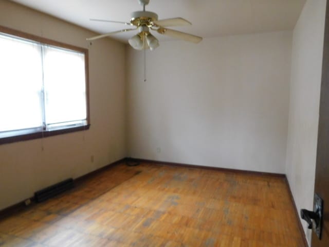 empty room with ceiling fan and hardwood / wood-style flooring