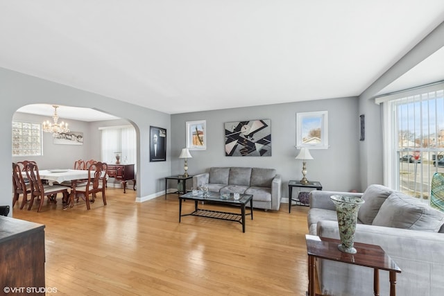 living room featuring light hardwood / wood-style flooring and an inviting chandelier