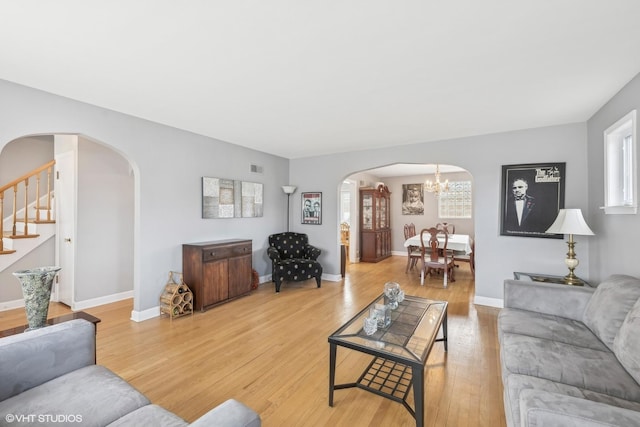 living room with hardwood / wood-style floors and an inviting chandelier