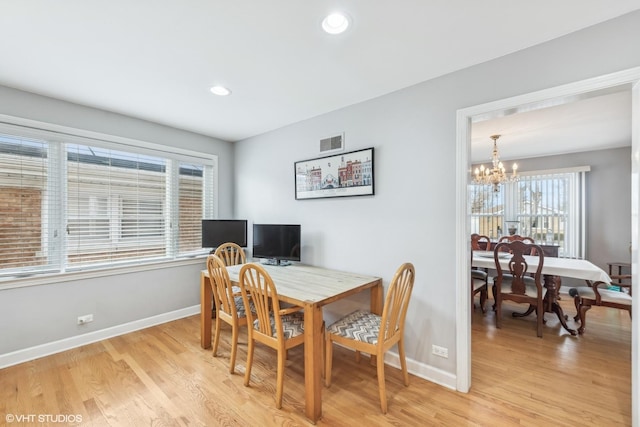 dining area featuring a notable chandelier and light hardwood / wood-style flooring